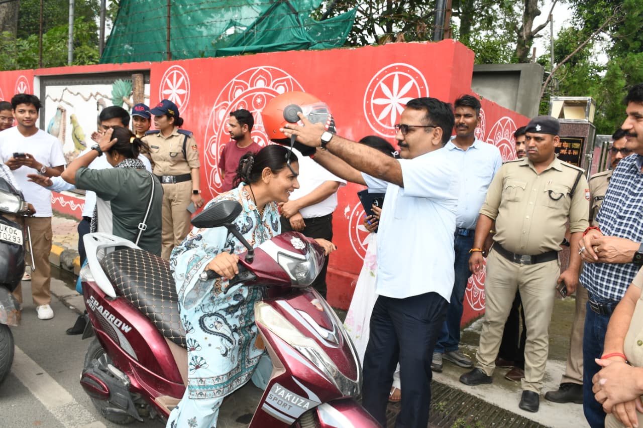 हल्द्वानी में जिला सड़क सुरक्षा समिति की बैठक लेते DM ललित मोहन रयाल और सड़क पर बिना हेलमेट चालकों को हेलमेट पहनाते हुए